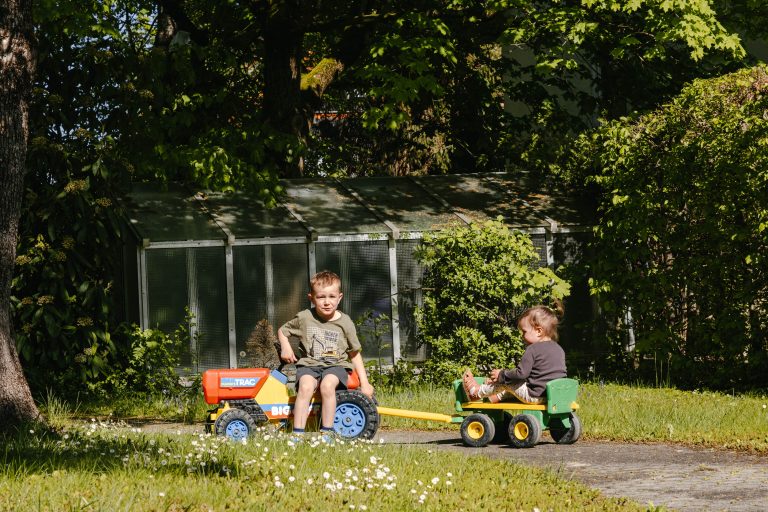 Geschwister spielen im Garten zusammen