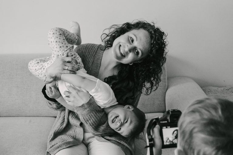 Der ältere Bruder macht ein Foto von der Mutter und seinem Geschwisterchen.