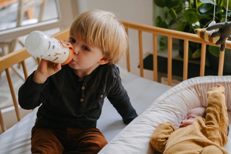 Bruder sitzt neben Wochenbett