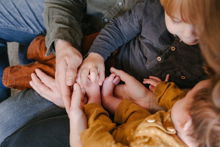 Die Familie hält die Babyfüße des jüngsten Familienmitglieds.