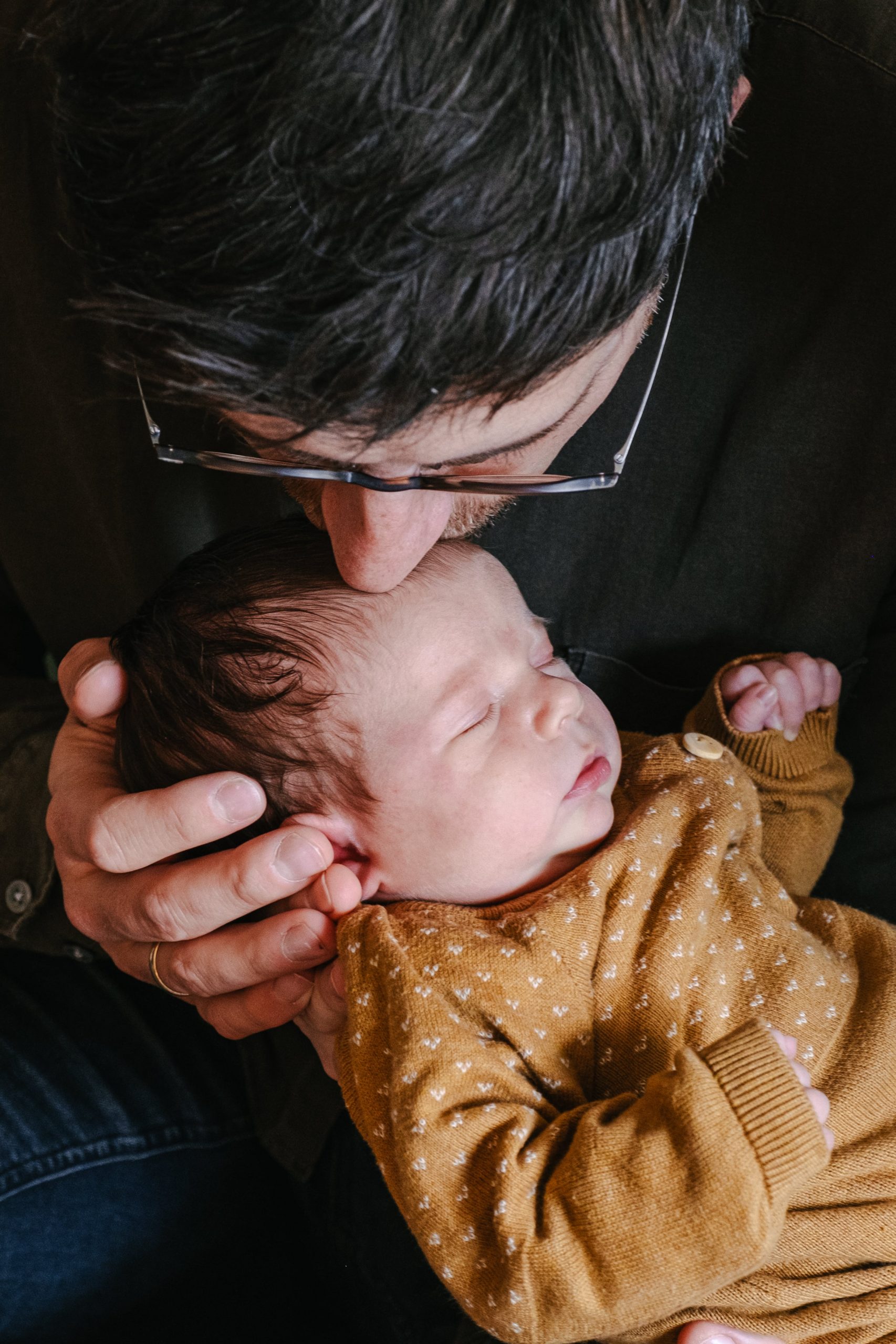 Vater hält sein neugeborenes Kind in den Armen