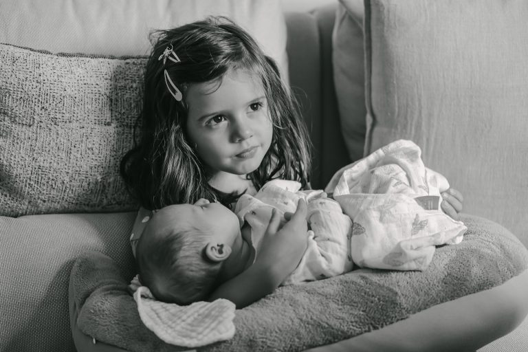 Mädchen hält Baby in den Armen